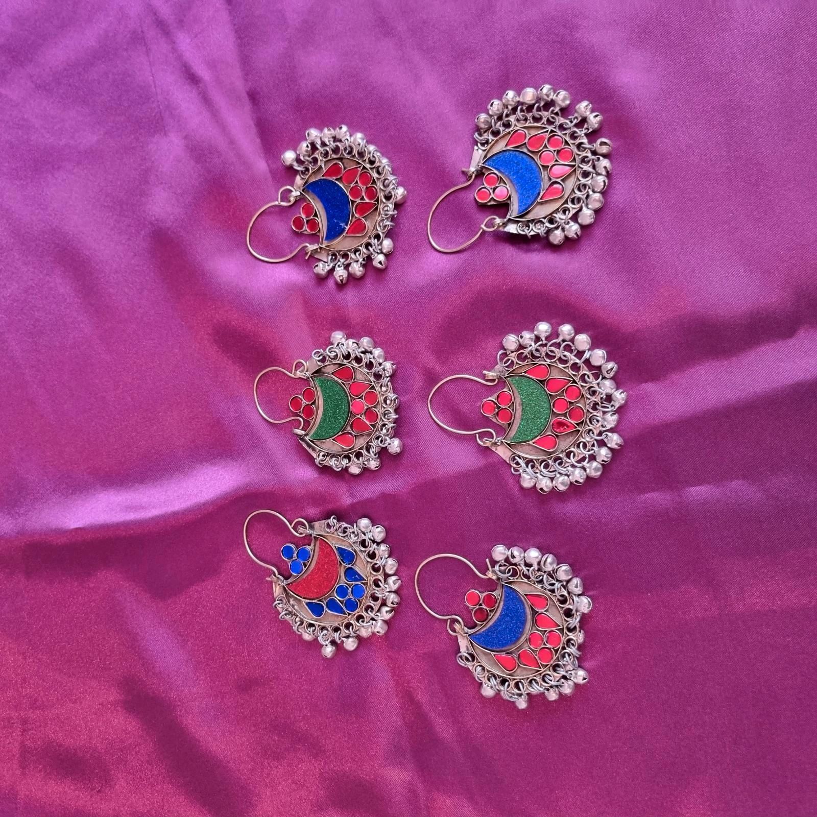 Sechs Paar Ohrringe liegen auf einem lila Tuch