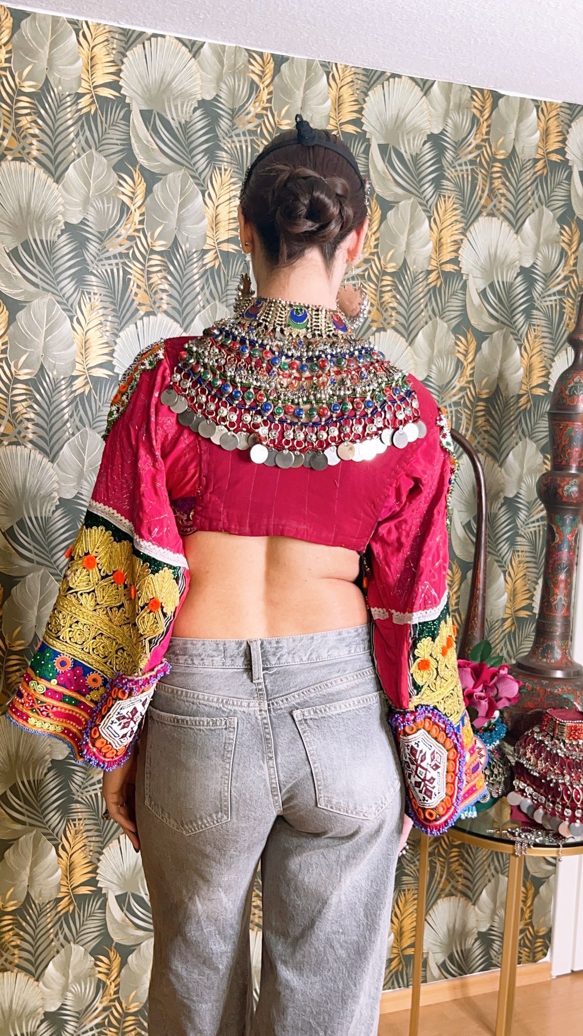 Der Rücken einer Frau, die ein bauchfreies Top und Jeans trägt.