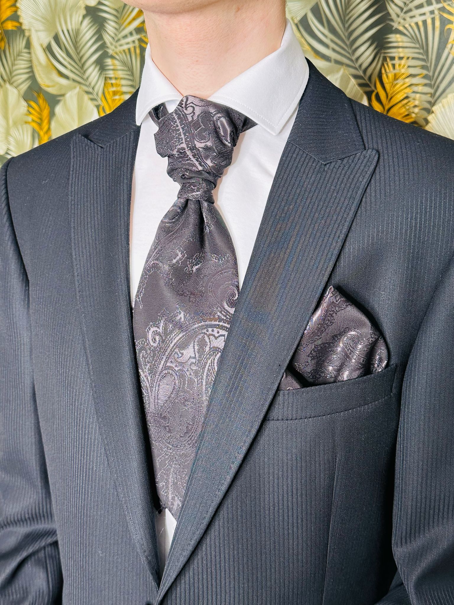 Ein Mann in Anzug, Krawatte und Einstecktuch.