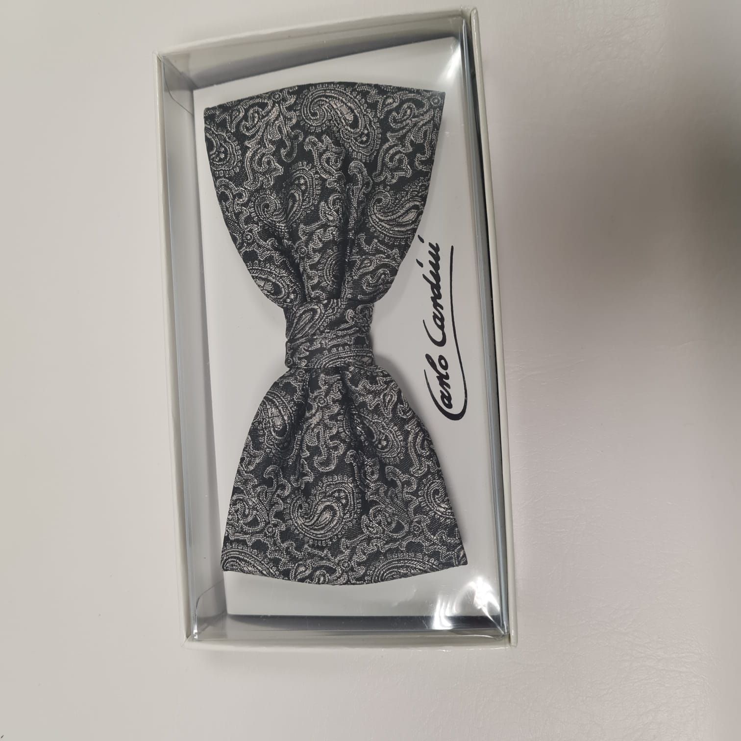 Eine schwarz-weiße Paisley-Fliege in einer durchsichtigen Box