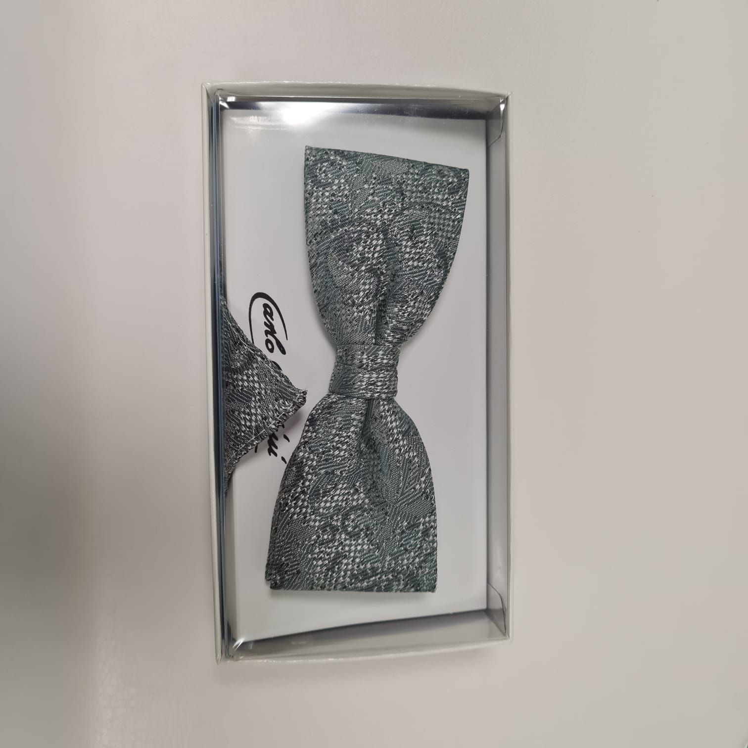 Ein Bild einer Fliege und eines Einstecktuchs in einer Schachtel