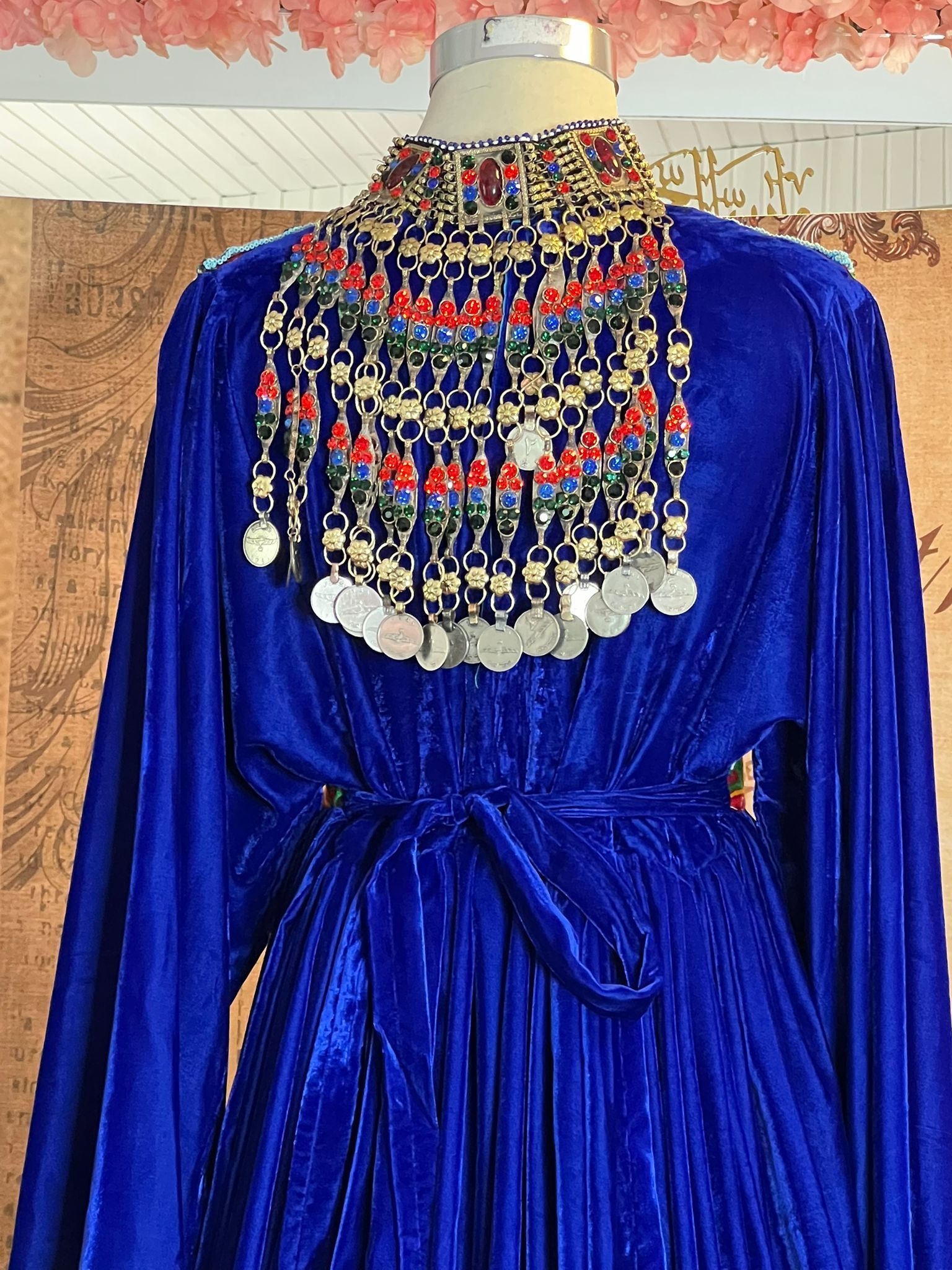 Ein blaues Kleid mit einer Halskette an einer Schaufensterpuppe.