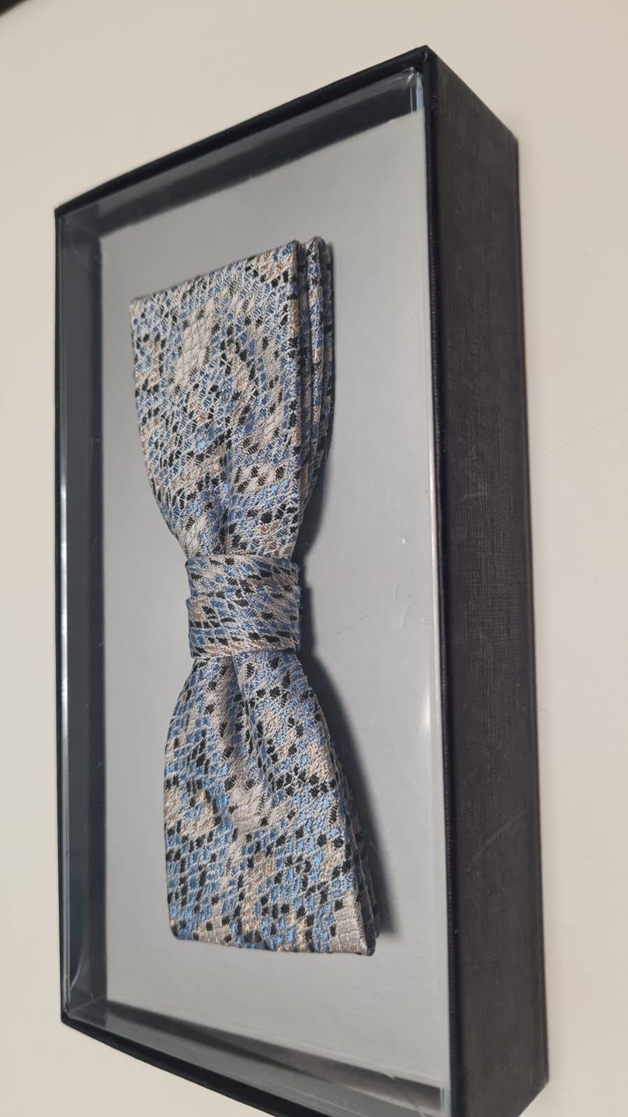 Ein Bild einer Fliege in einer Schachtel an einer Wand.