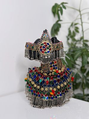 Eine Statue einer Frau sitzt auf einem Tisch mit einer Pflanze im Hintergrund