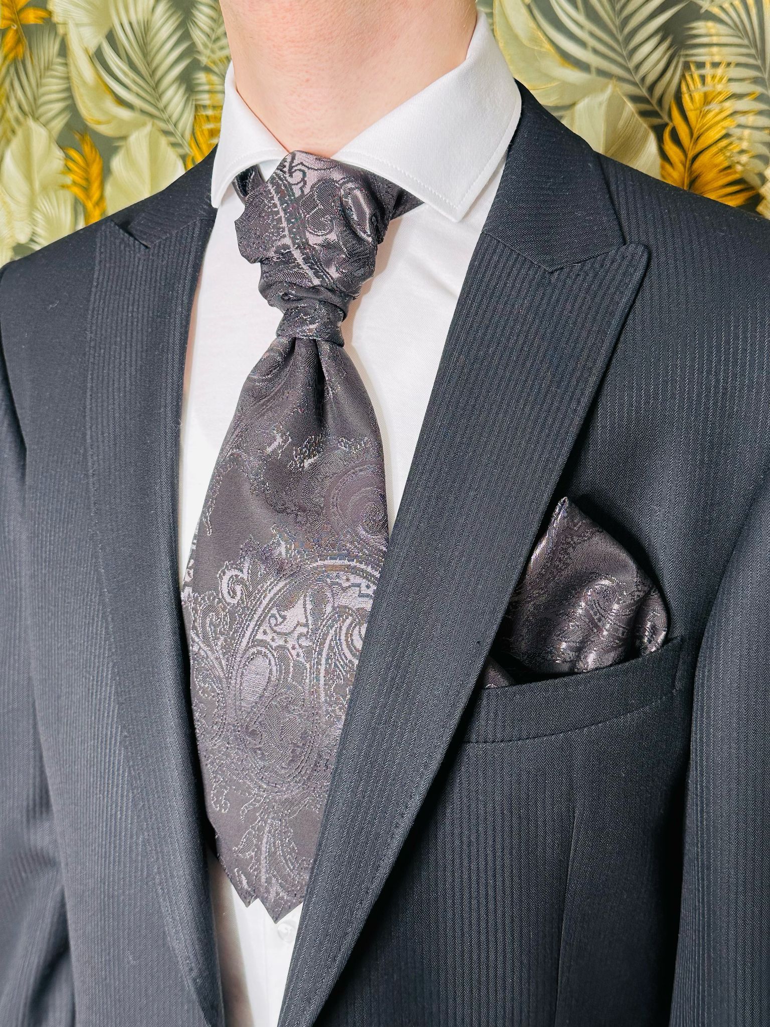 Ein Mann im Anzug mit Krawatte und Einstecktuch.