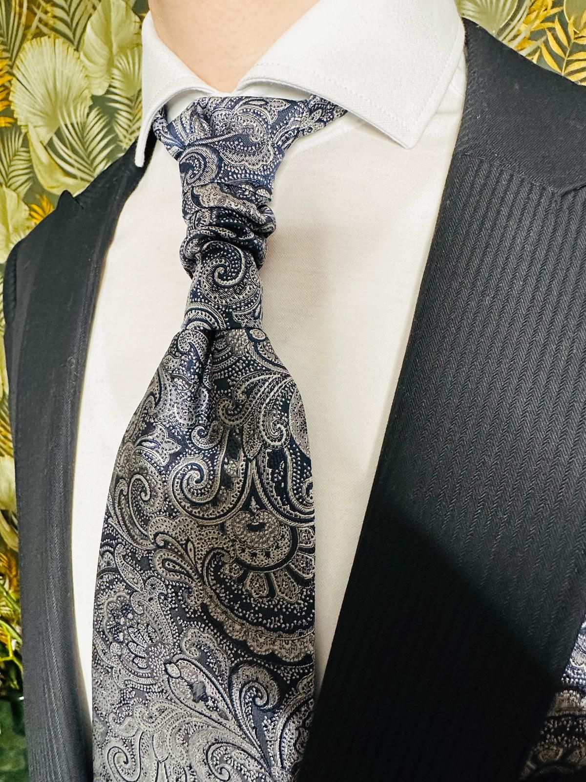 Ein Mann in Anzug und Krawatte mit Paisleymuster