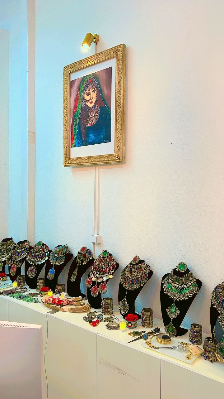 Ein Bild einer Frau hängt über einer Schmuckausstellung