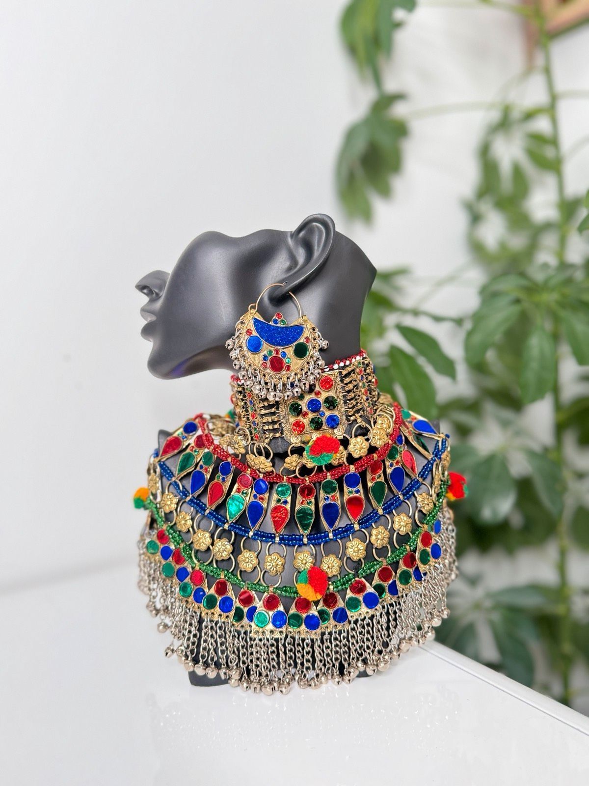 Eine Schaufensterpuppe mit Halskette und Ohrringen sitzt auf einem Tisch.