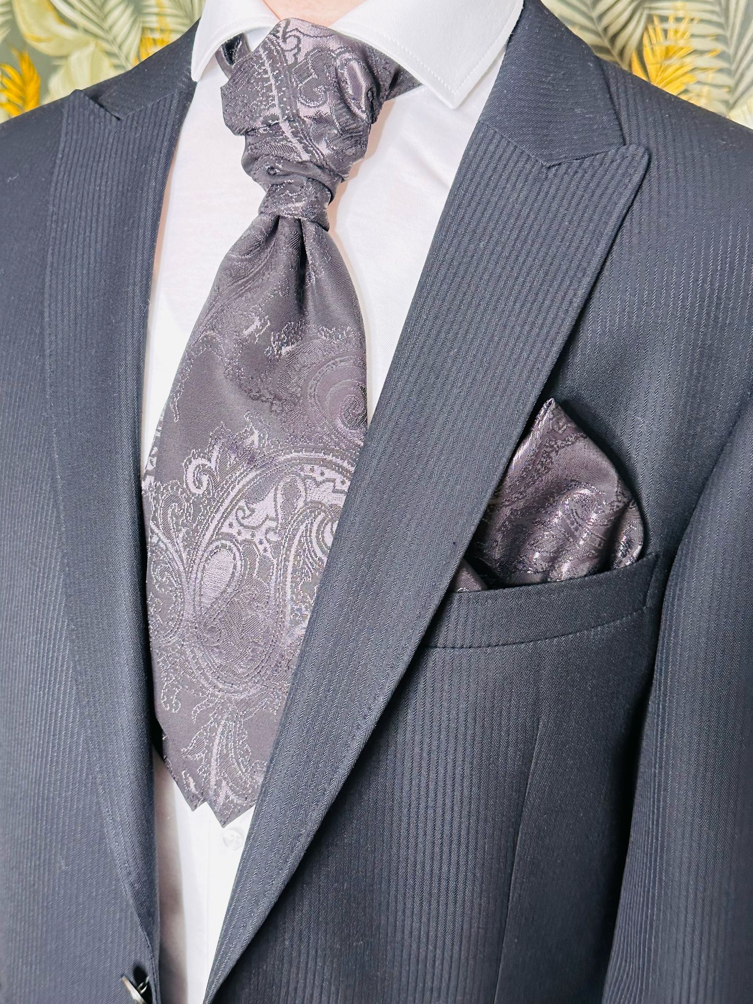 Ein Mann in Anzug, Krawatte und Einstecktuch.