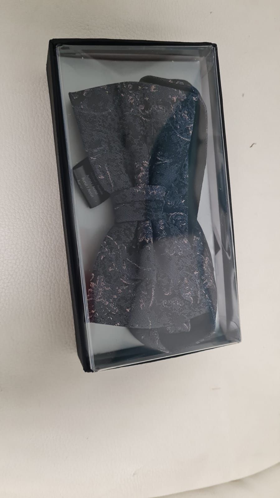 Eine Fliege liegt in einer Schachtel auf einem Tisch.