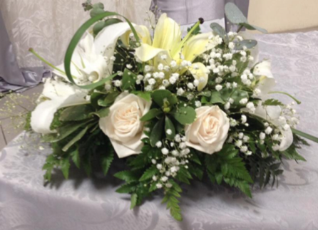 Un ramo de flores blancas está sobre una mesa.