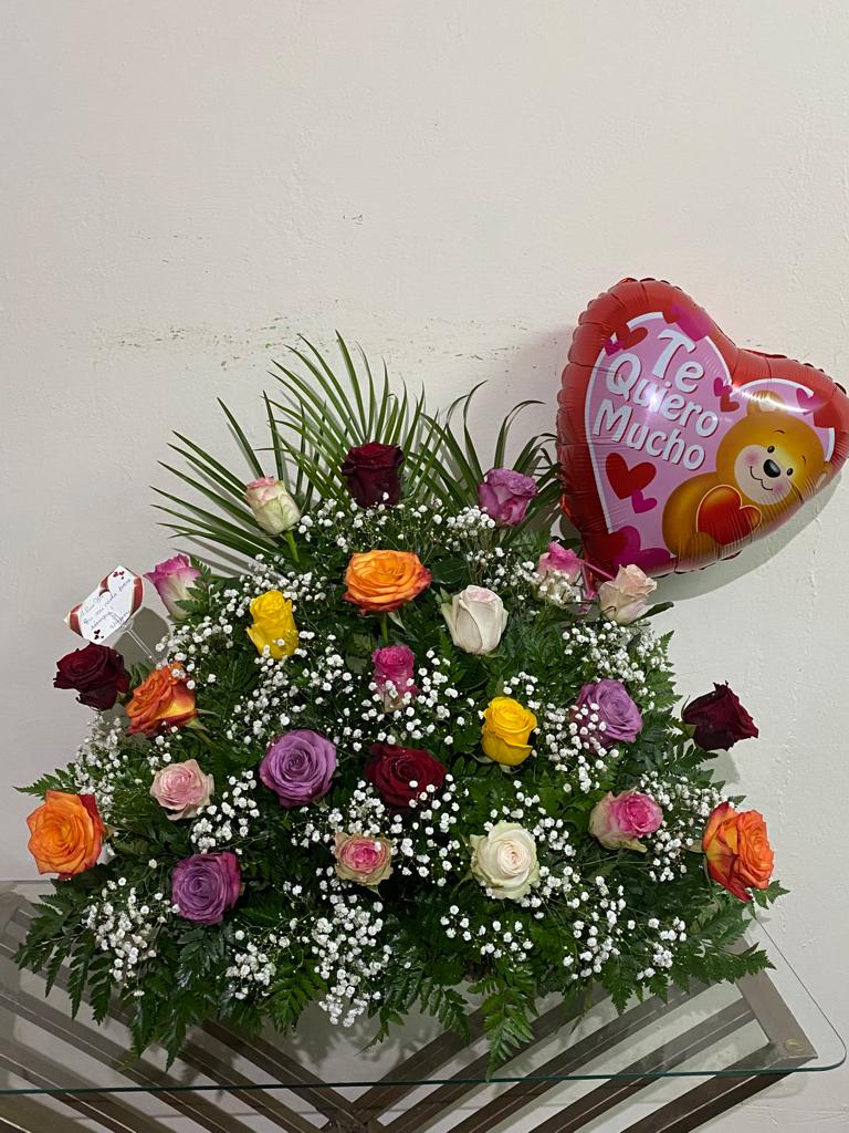 Un ramo de flores y un globo en forma de corazón sobre una mesa.