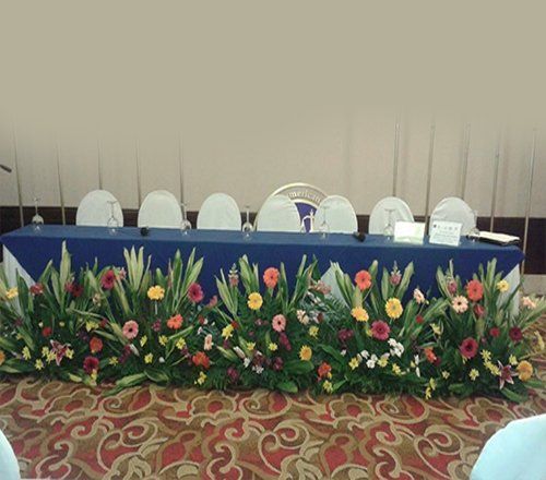 Una mesa larga con flores en una habitación.