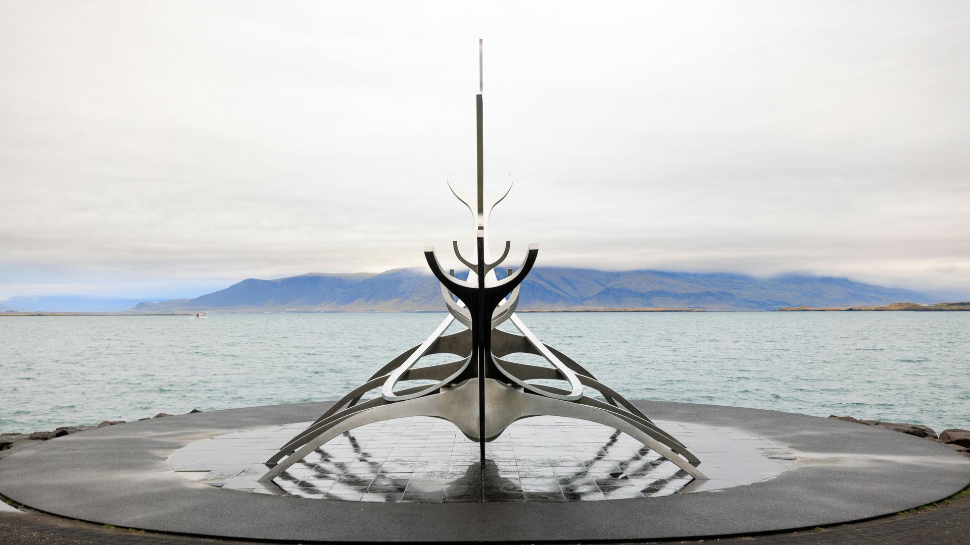 Sólfarið (Sun Voyager) sculpture in Reykjavik, Iceland, against a calm sea and overcast sky.