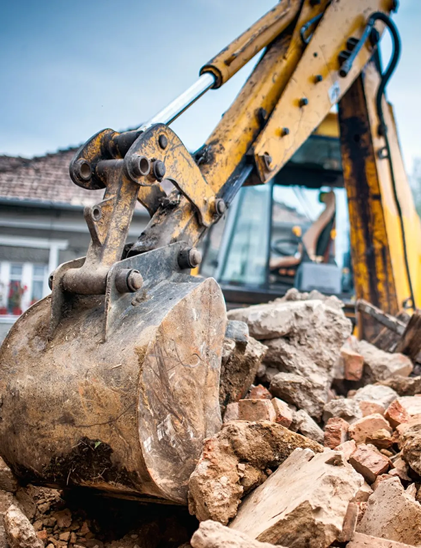 Un bulldozer retire des pierres d'un tas de décombres.