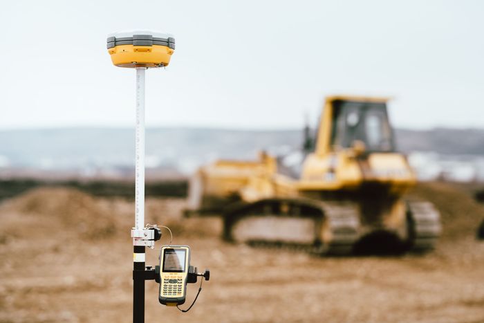 Un bulldozer jaune est à l'arrière-plan d'un chantier de construction.