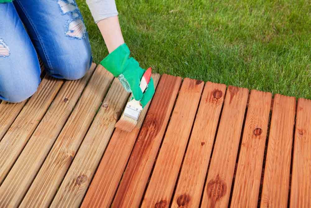 Applying Protective Varnish On Wooden Deck