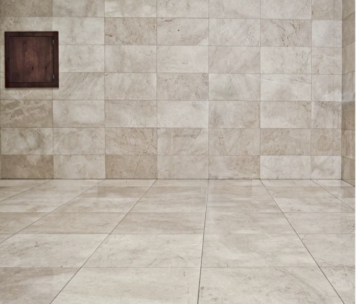 Una stanza vuota con pavimento piastrellato e pareti di marmo