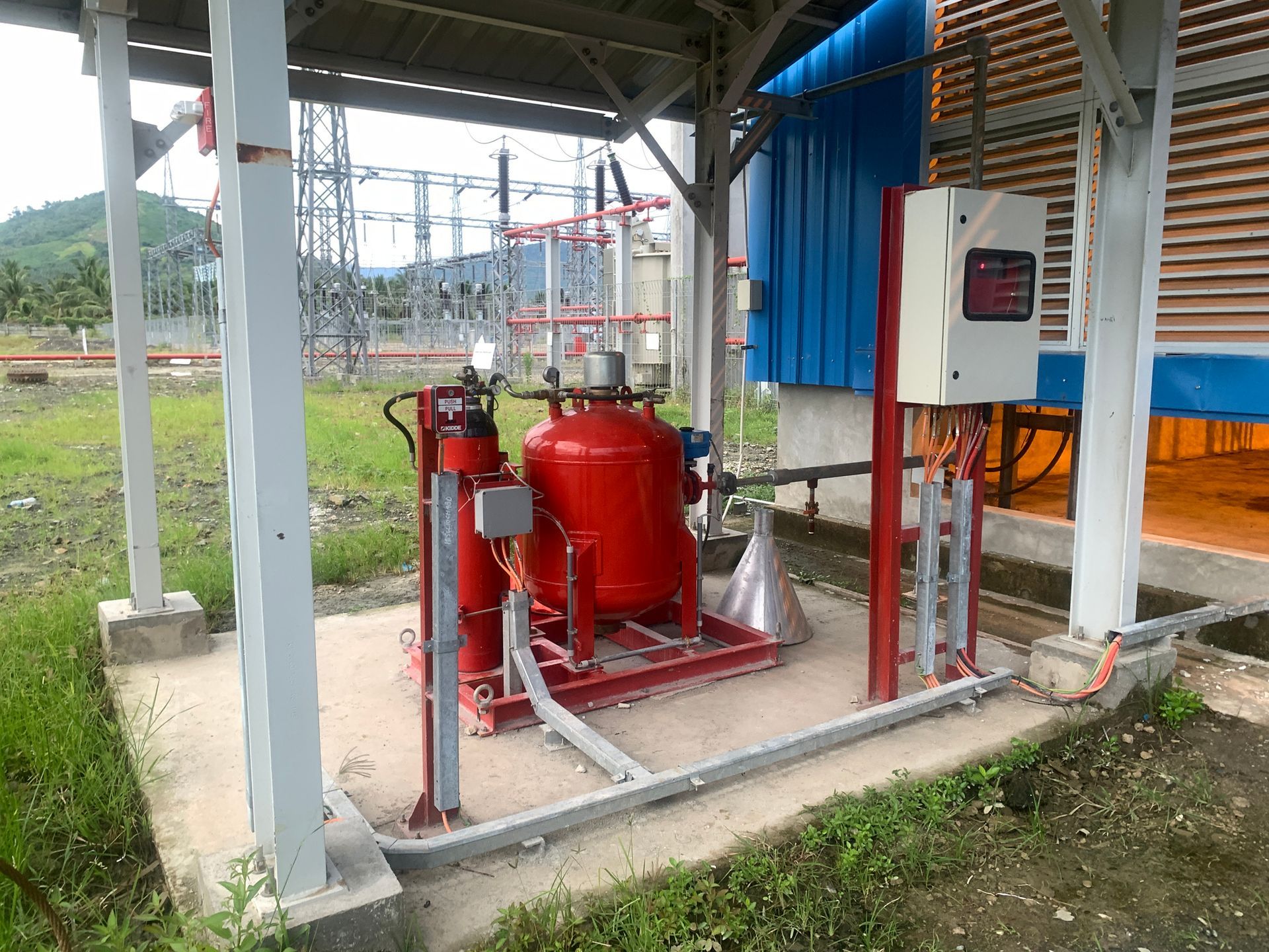 Red fire suppression system in an industrial setting, with electrical components and infrastructure.