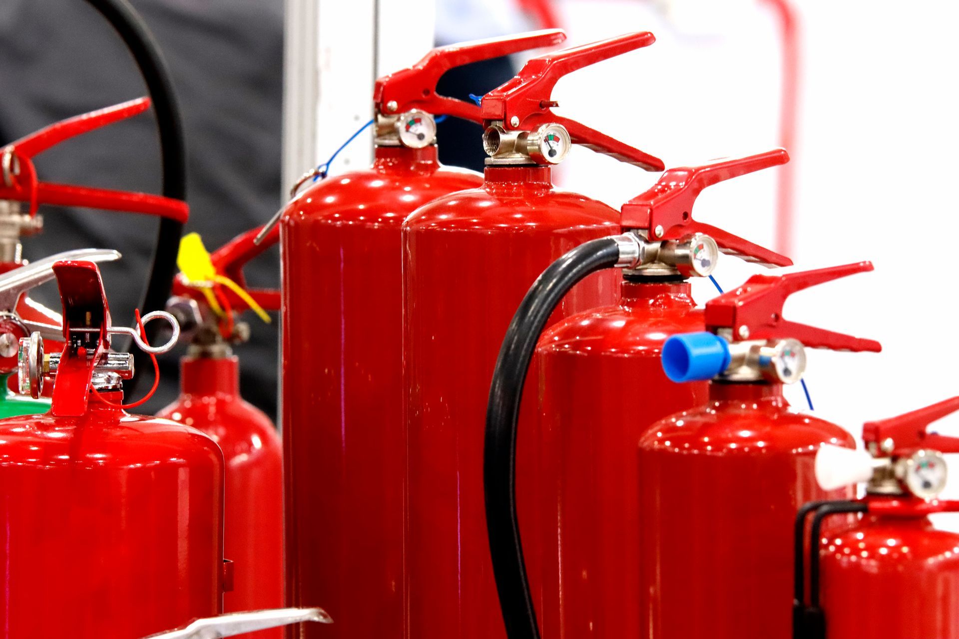 Red fire extinguishers with red handles, ready for use.