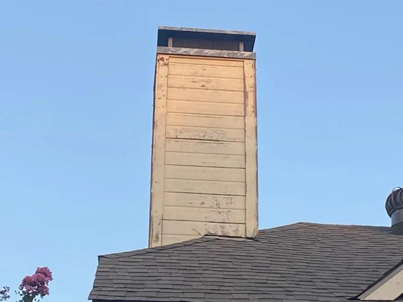 A chimney on top of a roof with a blue sky in the background