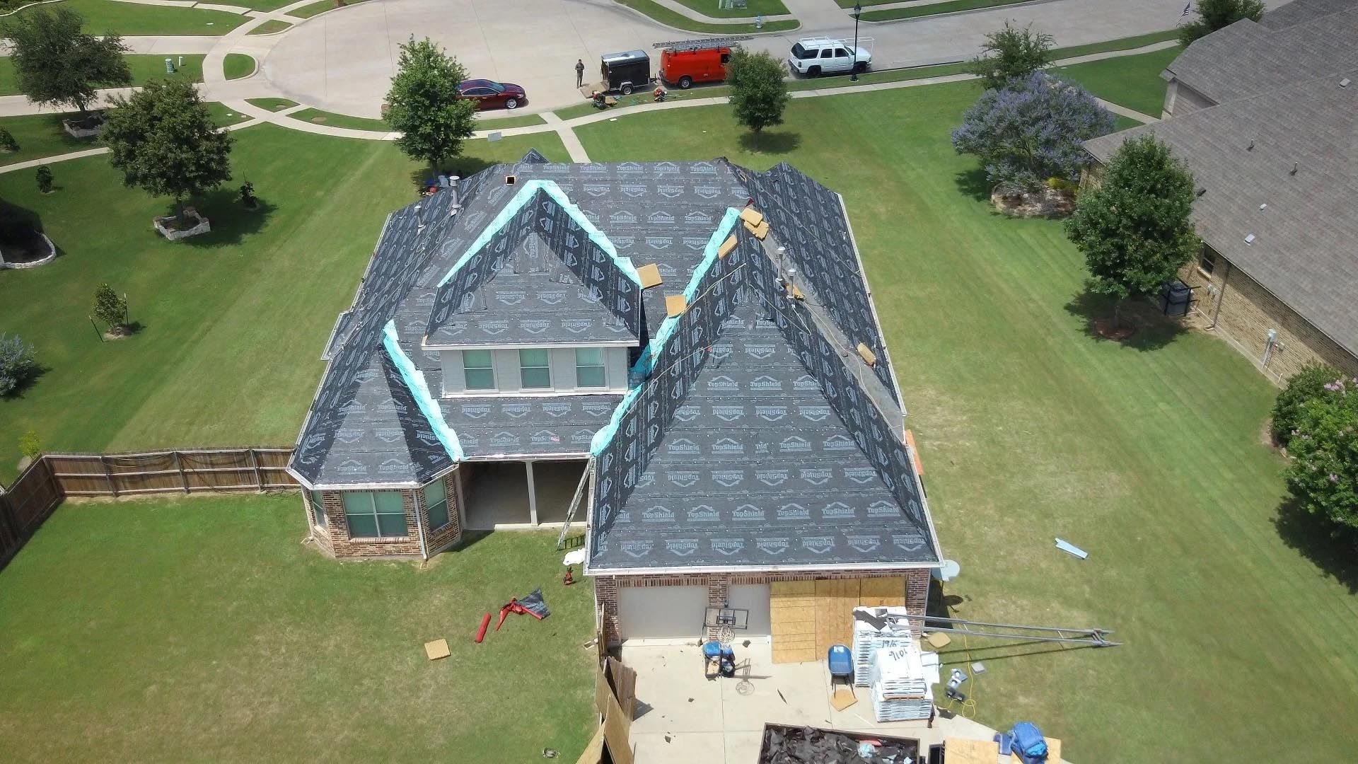 An aerial view of a house with a roof being installed.