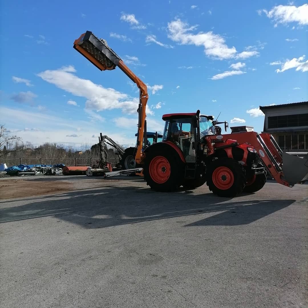 Un trattore è parcheggiato in un parcheggio con un carrello elevatore attaccato ad esso