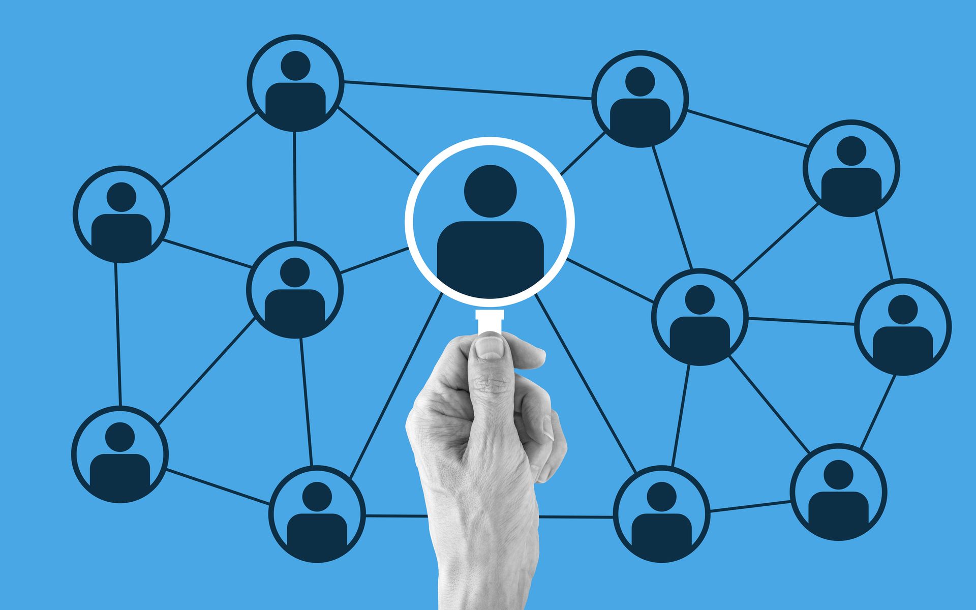 Una mano tiene una lente di ingrandimento su una rete di persone.