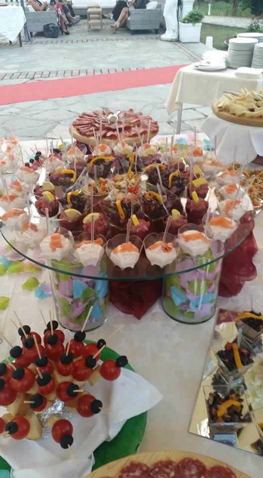 Un tavolo da buffet con tanto cibo sopra e un tappeto rosso.