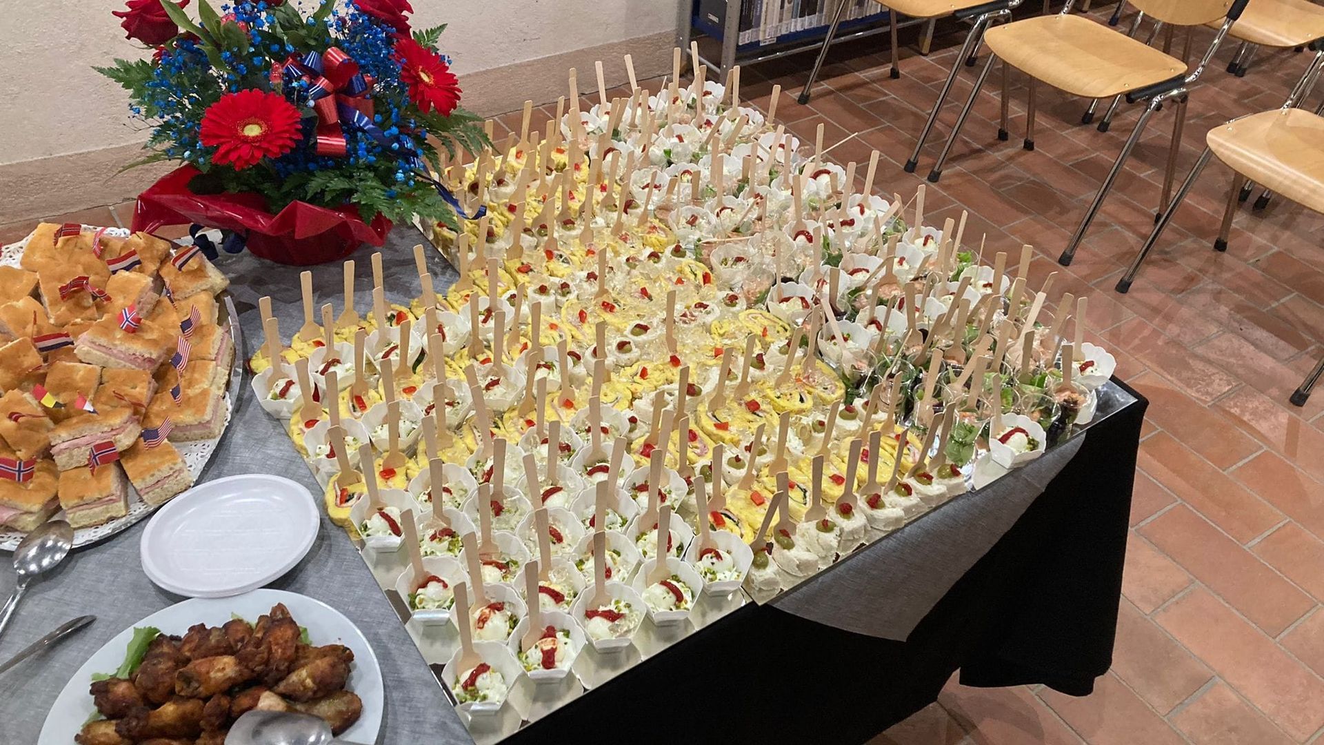 Un tavolo da buffet pieno di cibo e fiori.