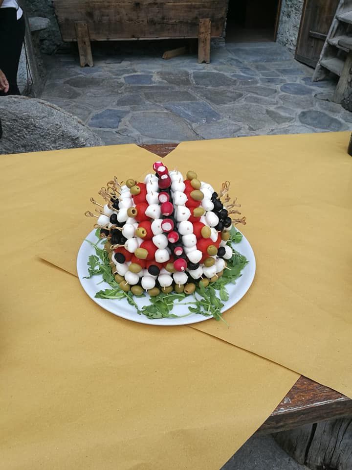 Un piatto bianco con sopra una torta e delle verdure su un tavolo.