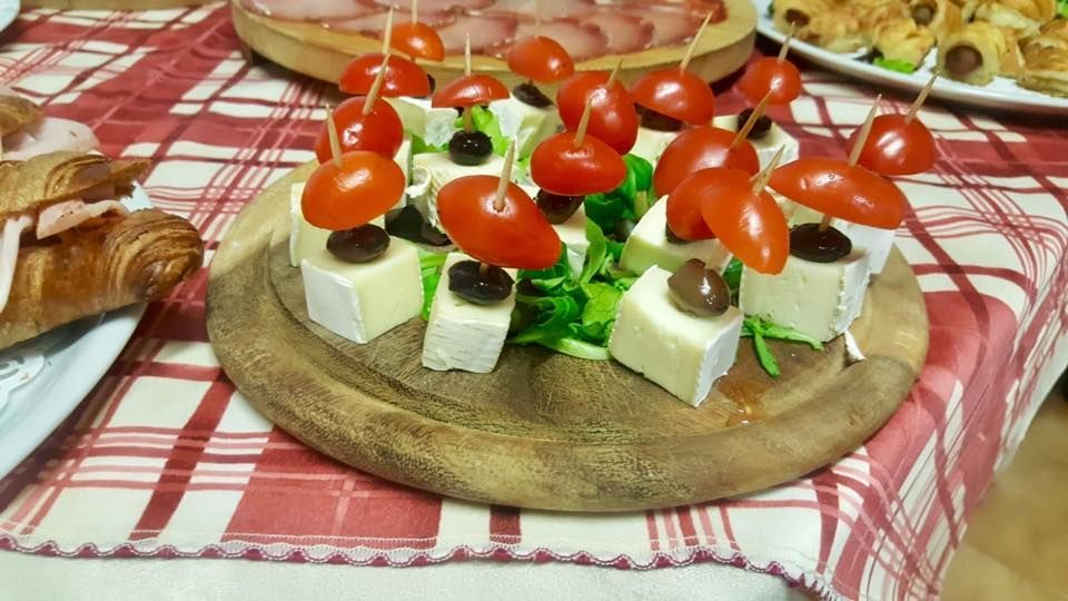 Un tagliere di legno con sopra formaggio e pomodori su un tavolo.
