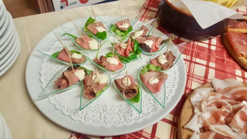 Un piatto di cibo su un tavolo con una pizza sullo sfondo