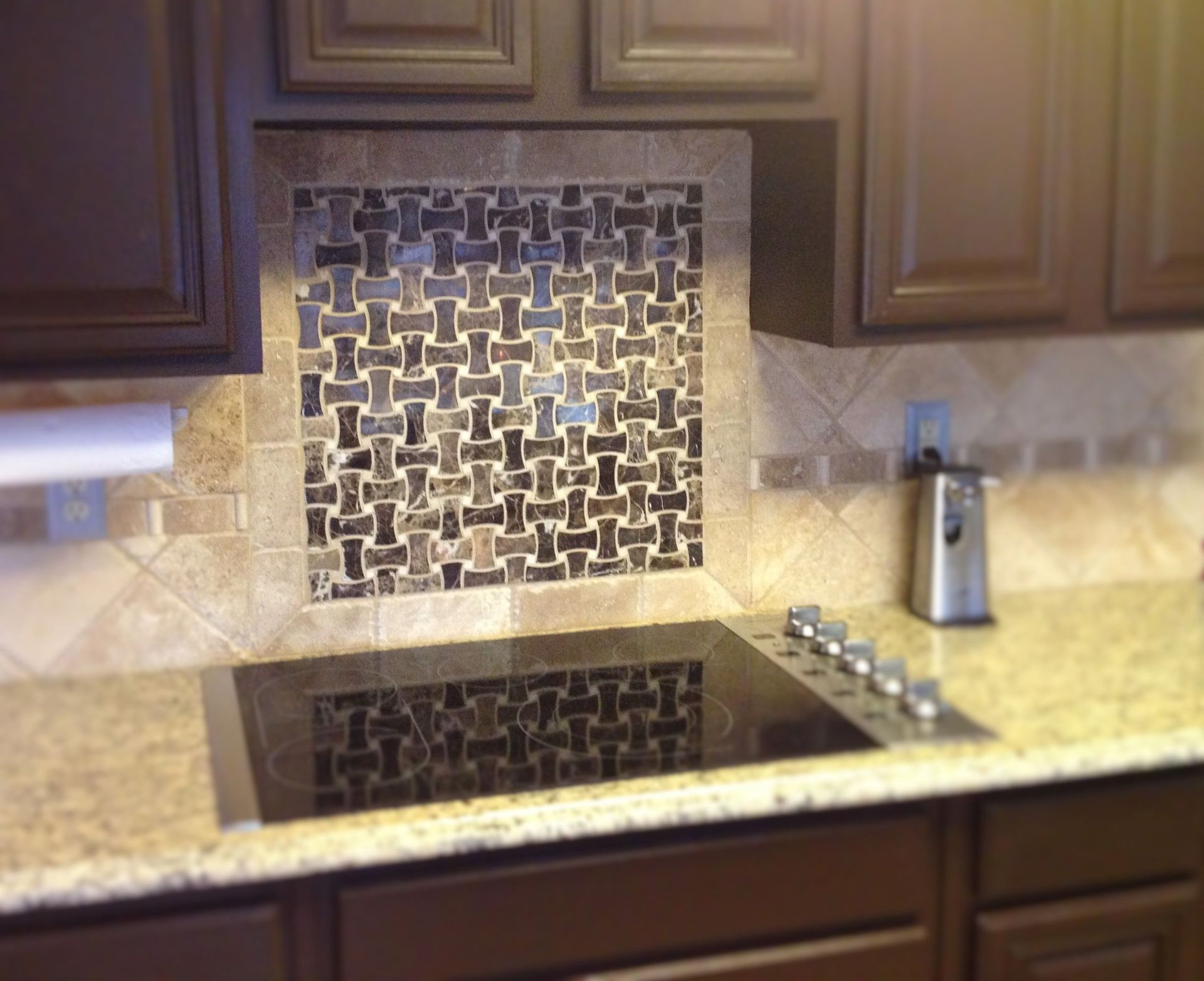 A kitchen with a stove top oven and granite counter tops.