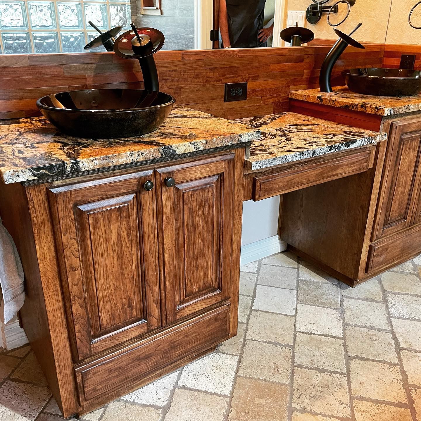A bathroom with two sinks and wooden cabinets