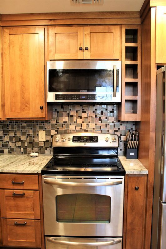 A kitchen with stainless steel appliances and wooden cabinets.