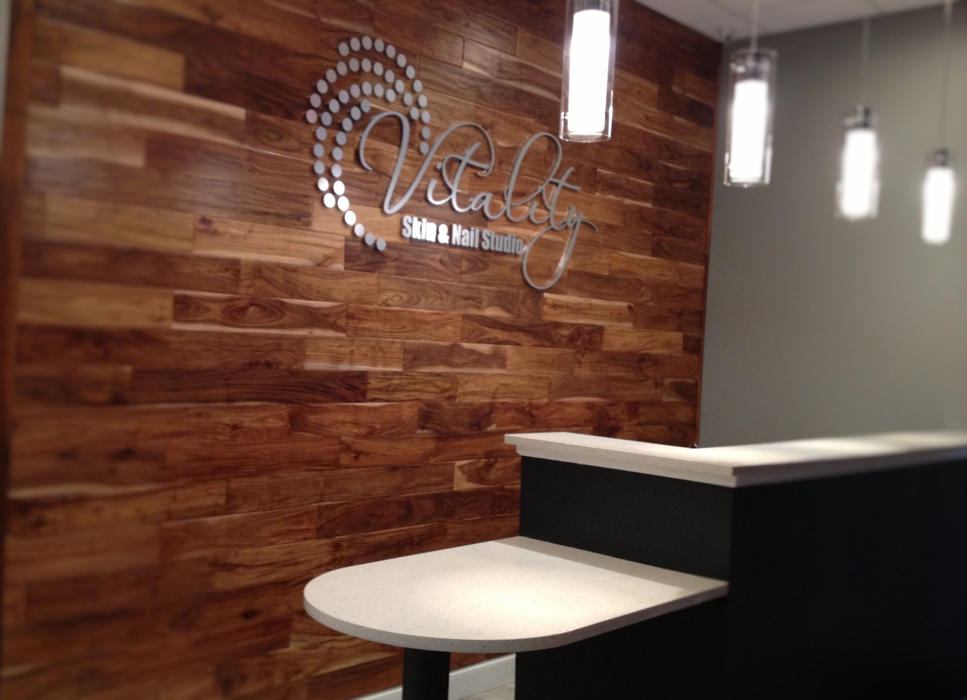 A reception area with a wooden wall and a table.