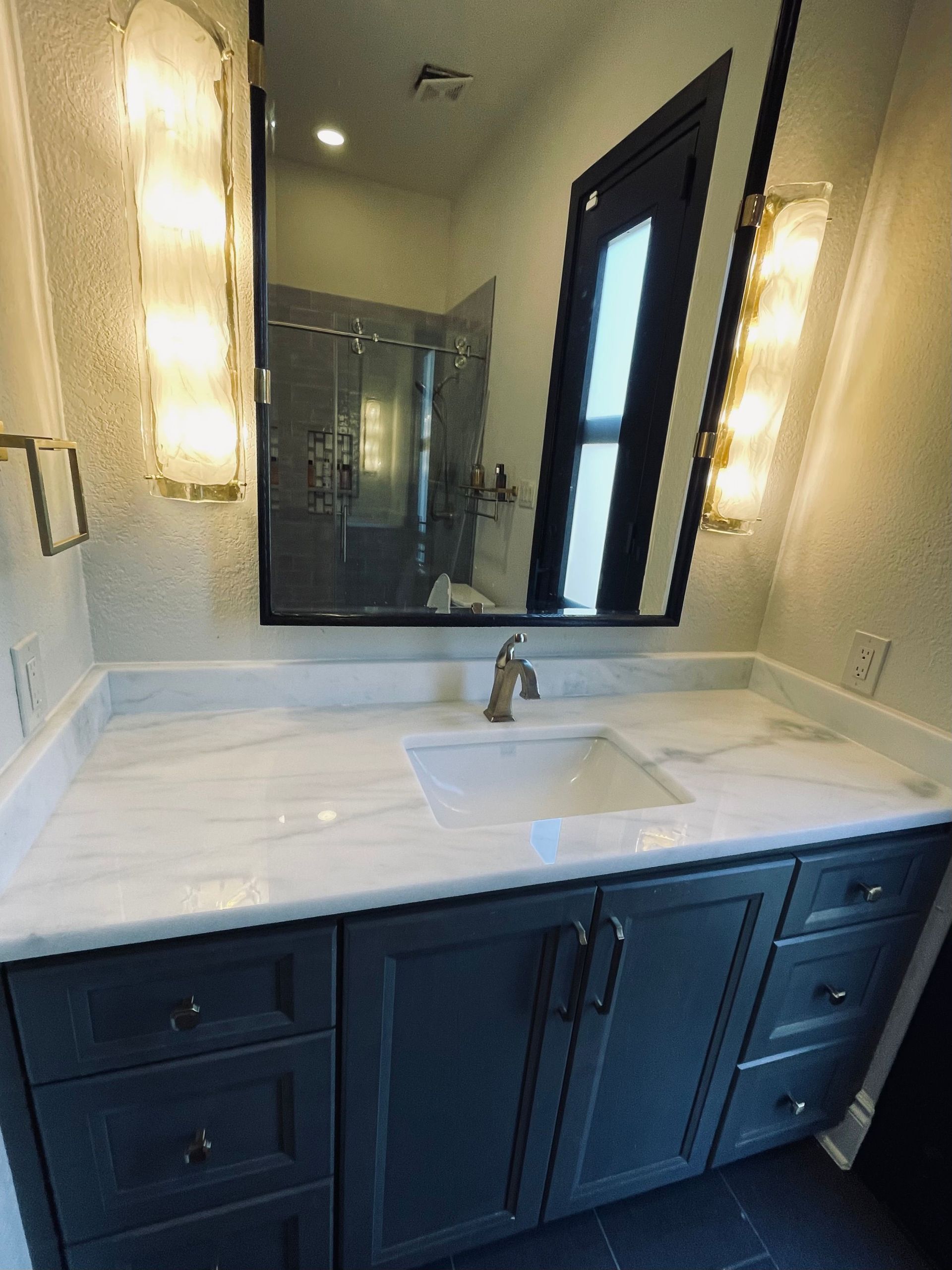A bathroom with a sink and a large mirror