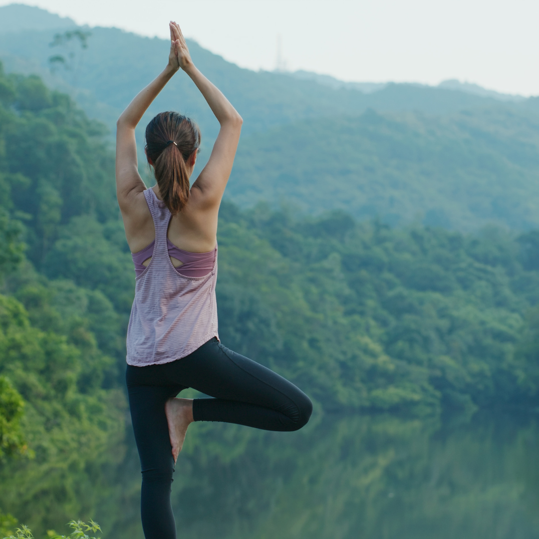 Woman practicing yoga outdoors, representing balance, stress relief, and holistic hormone wellness