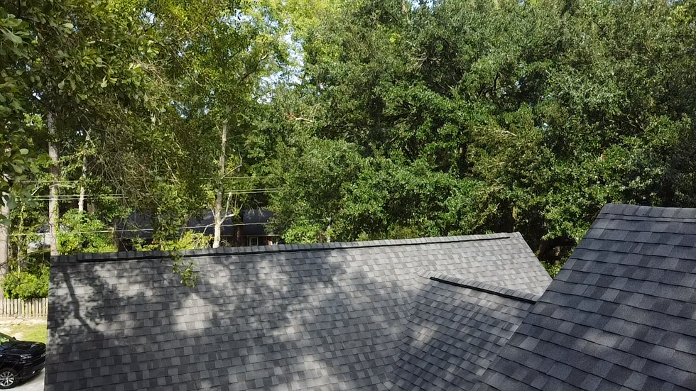 A roof of a house with a lot of trees in the background.