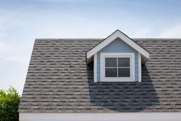 The roof of a house with a window on it.