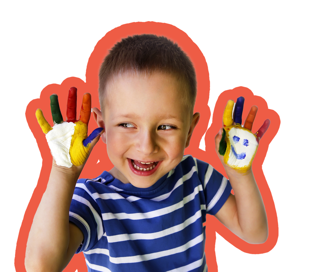 A smiling young boy with colorful paint on his hands, including a painted smiley face, in a blue striped shirt.