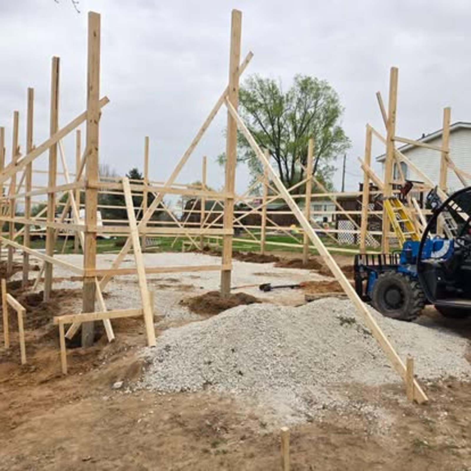 A blue atv is parked in front of a building under construction.