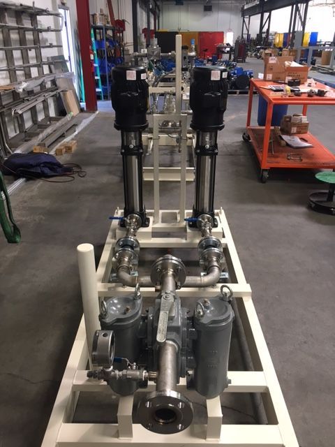 A machine is sitting in a room with a lot of pipes and pumps