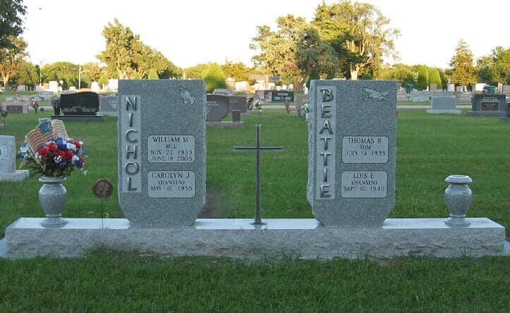 Family monument in gray granite accented with aluminum letters and large center cross