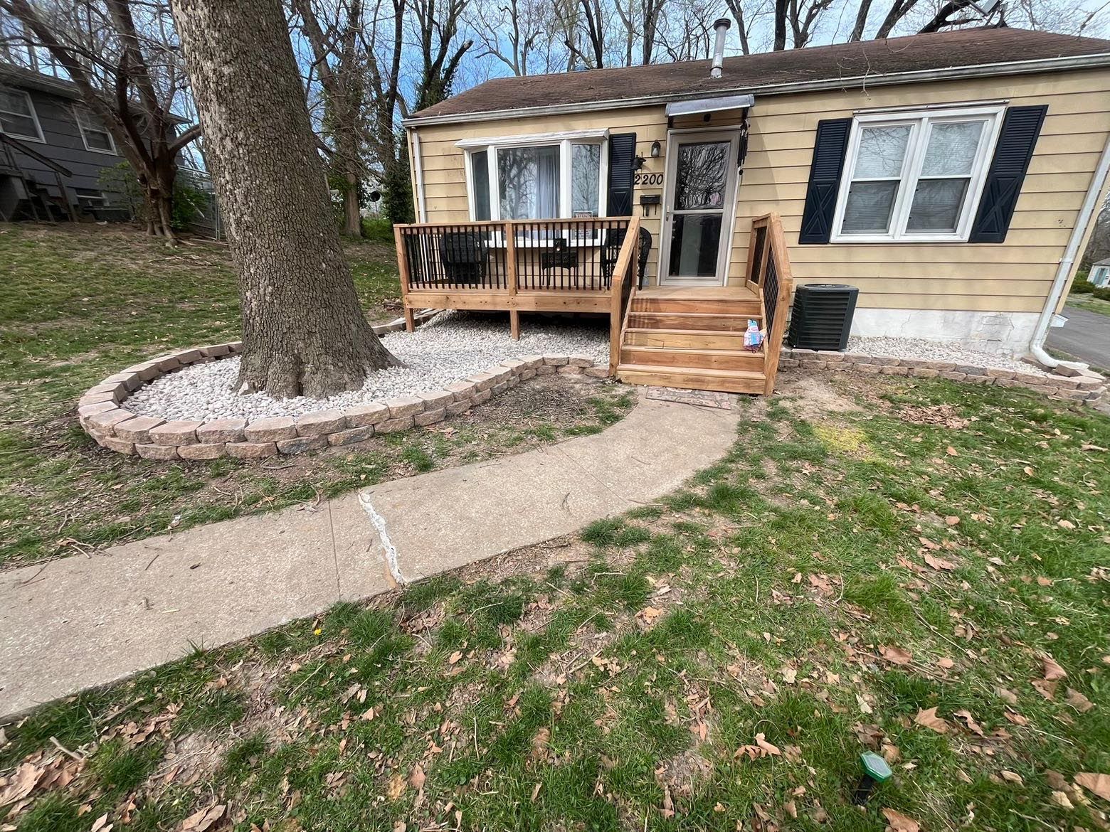 A small house with a deck and stairs in front of it.