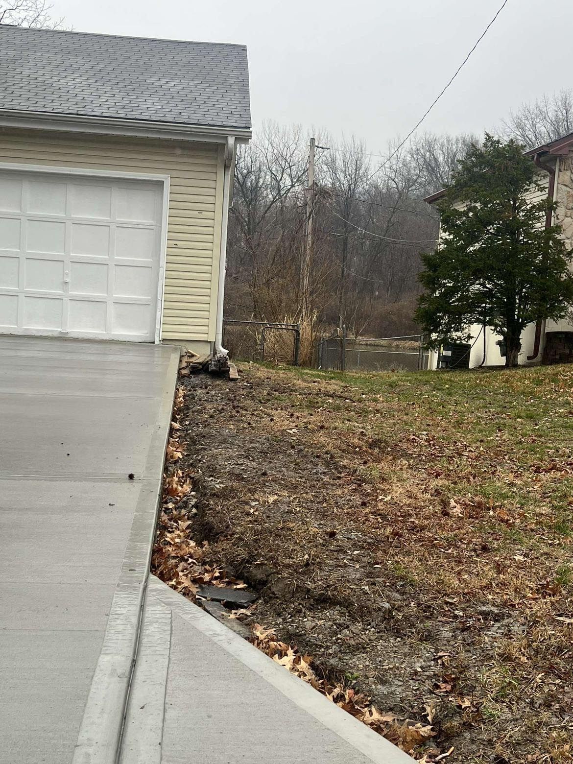 A concrete driveway leading to a garage with a white garage door.