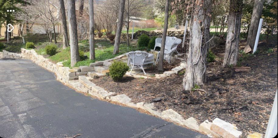 A driveway leading to a house surrounded by trees and bushes.