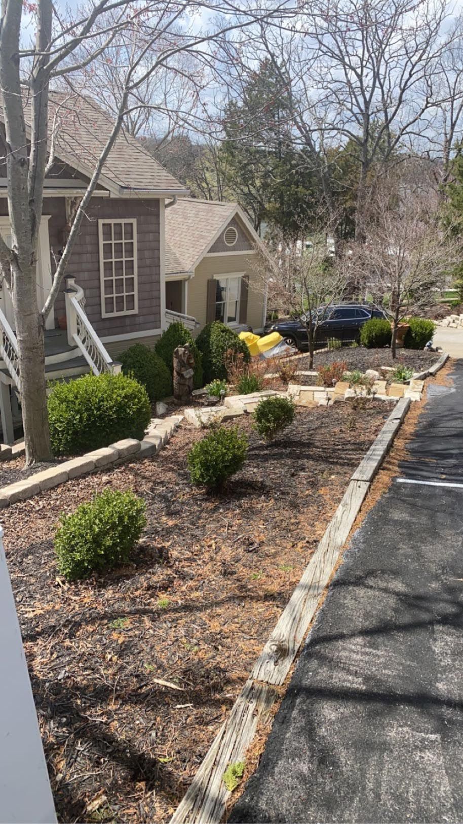 A house is sitting on top of a hill next to a parking lot.