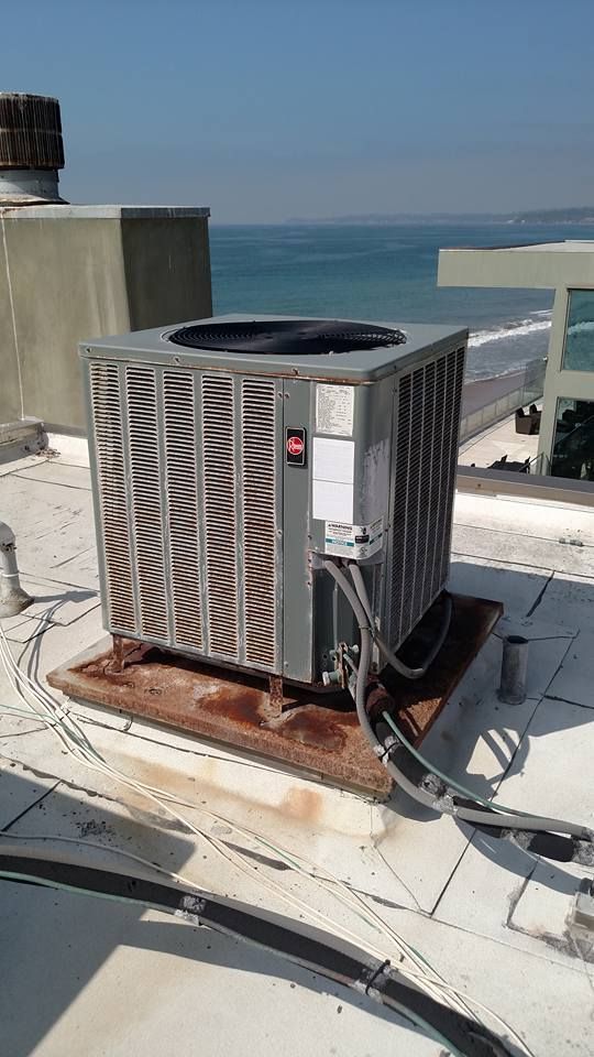 Air conditioner on a rooftop, with ocean in the background.